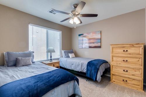a bedroom with two beds and a ceiling fan at Palmen Maricopa in Maricopa