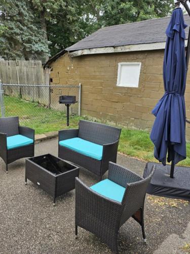 a patio with chairs and an umbrella and a grill at Fab 50's Firestone Flat! in Akron