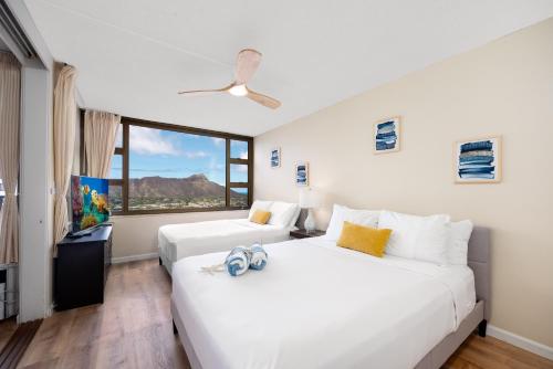 two beds in a room with a window at 34th floor lanai with Diamond Head views, pool & hot tub access in Honolulu