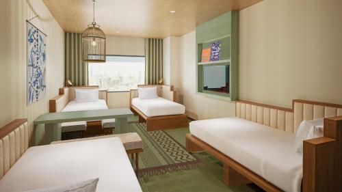 a small room with two beds and a table at The Royal Park Hotel Maihama Resort Tokyo Bay in Urayasu