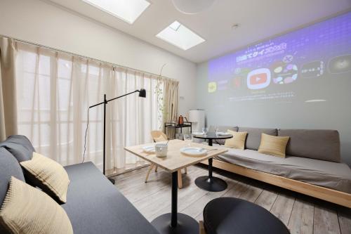 a living room with a couch and a large screen at Lido East Shinagawa　 in Tokyo