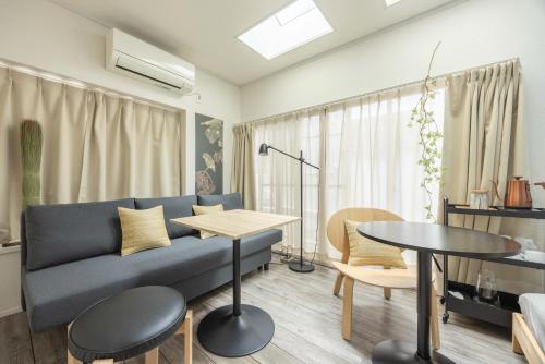 a living room with a blue couch and a table at Lido East Shinagawa　 in Tokyo