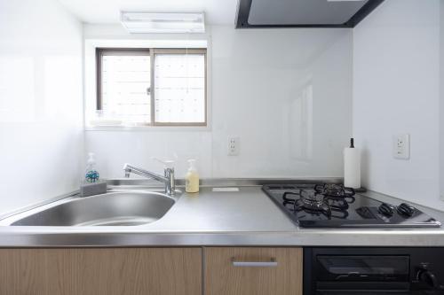 a kitchen with a sink and a stove at Lido East Shinagawa　 in Tokyo