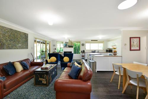 a living room with a couch and a table and a kitchen at 4BR 2BA Cozy Blackheath Cottage with Firepit & Pool Table in Blackheath