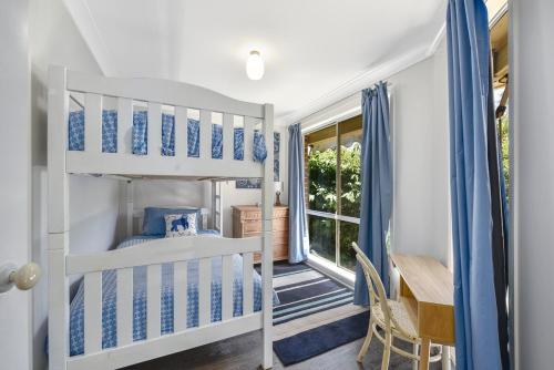 黑荒地4BR 2BA Cozy Blackheath Cottage with Firepit & Pool Table的一间卧室配有一张双层床、一张桌子和一张书桌。