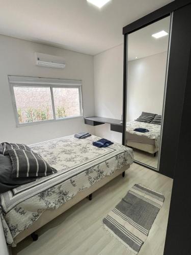 a bedroom with two beds and a large mirror at Espaço Ideal in Passos