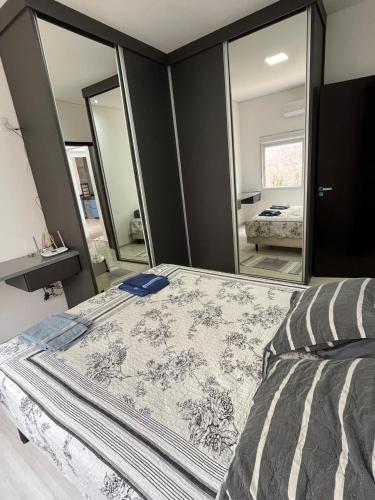 a bedroom with a bed and a large mirror at Espaço Ideal in Passos