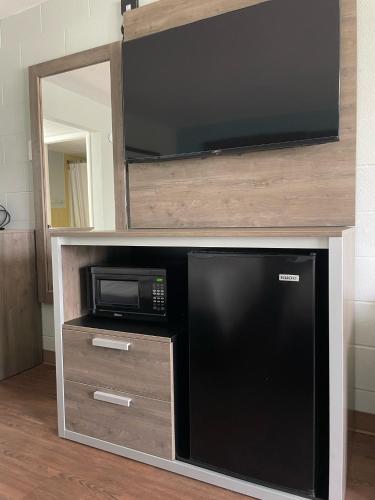 a entertainment center with a microwave and a television at Buccaneer Inn in St. George Island