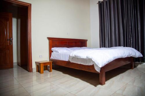 a bedroom with a large bed with white sheets at 2 Bedroom Suite with Sitting Area in Kigali
