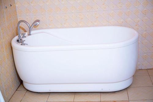 a white bath tub in a bathroom with a sink at 2 Bedroom Suite with Sitting Area in Kigali
