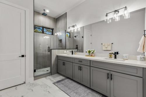 a white bathroom with two sinks and a shower at Cottonrose Flagstaff in Flagstaff