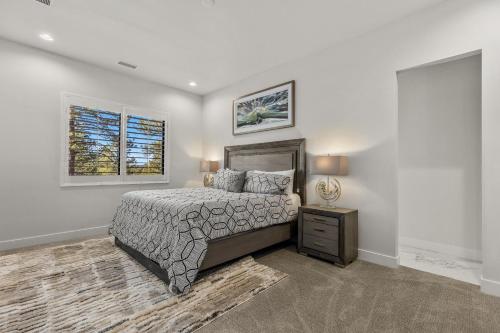 a bedroom with a bed and a nightstand and a window at Cottonrose Flagstaff in Flagstaff
