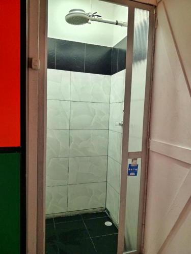 a shower with a glass door in a bathroom at Ayllu Hostel in Bogotá