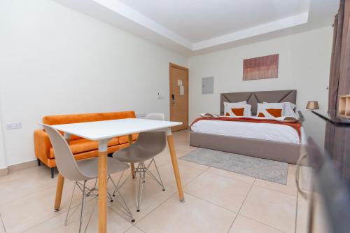 a bedroom with a bed and a table and chairs at CasaNova Airport Suites in Accra