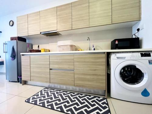 a kitchen with a washing machine and a refrigerator at Blissful Homes at i-City - WiFi TV Box 1 Carpark in Shah Alam