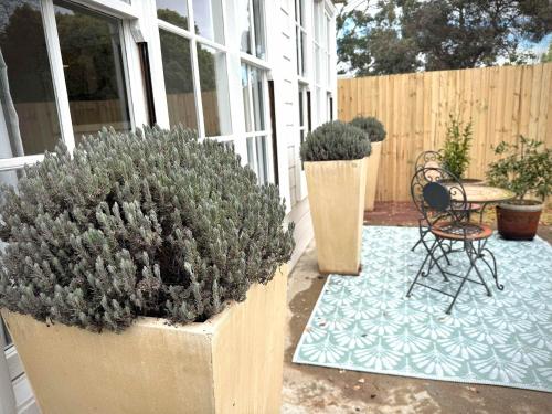 a patio with potted plants and a table and chairs at The Summer Cottage in Orange