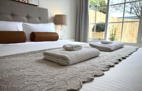 a bedroom with a bed with two towels on it at The Summer Cottage in Orange
