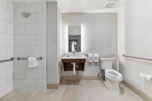 a white bathroom with a toilet and a sink at Holiday Inn Express & Suites Mountain View Silicon Valley by IHG in Mountain View