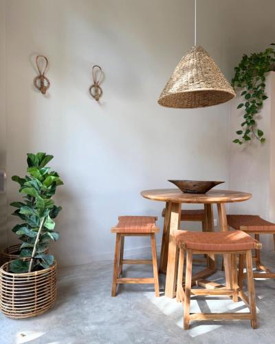 a table and two stools and a potted plant at La Playa Studios Hiriketiya in Hiriketiya