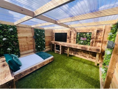 an outdoor room with a bed and a television at Woodlakes Park By Liv Retreats in Kings Lynn