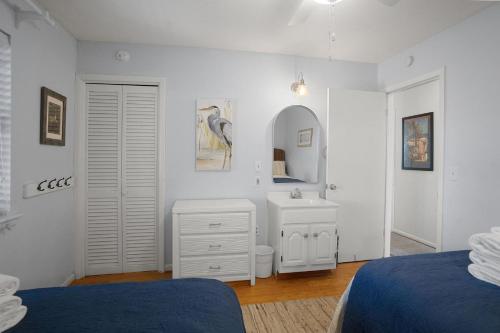 a bedroom with two beds and a sink and a mirror at Sprawling Family Home w/ Pool Table - Steps from Beach, Tennis, & Pools in Fripp Island