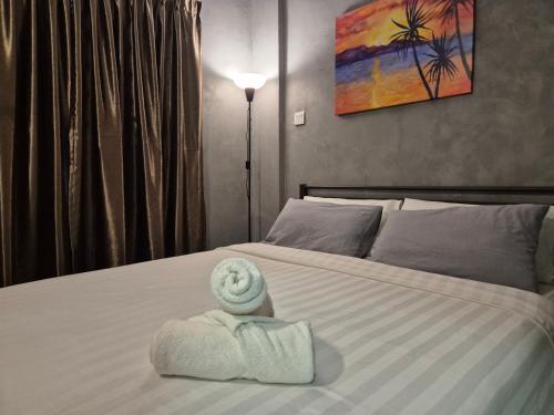 a room with a bed with a towel on it at 10pax GFloor 2R2B DUAL-KEY SEASIDE, WATERSPORT, FREE BBQ Set, Pool, Wifi, 50"TV in Port Dickson