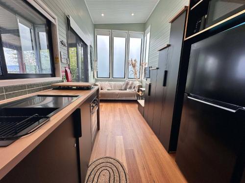 a kitchen with a sink and a couch in a room at Cudgeree Tiny for Two in Windang