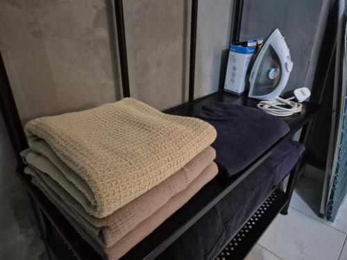 a pile of towels on a table in a bathroom at 10pax GFloor 2R2B DUAL-KEY SEASIDE, WATERSPORT, FREE BBQ Set, Pool, Wifi, 50"TV in Port Dickson