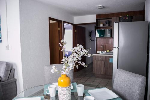 a kitchen with a glass table with a vase with flowers at Moderno Departamento 2 Centro Historico - Modern Apartment 2 Downtown in San Luis Potosí