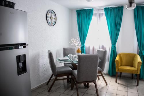 a dining room with blue curtains and a table and chairs at Moderno Departamento 2 Centro Historico - Modern Apartment 2 Downtown in San Luis Potosí