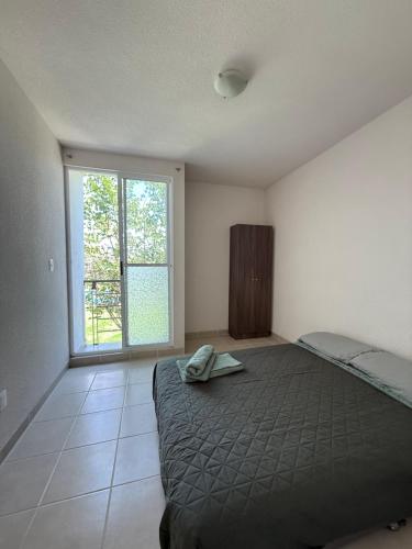 a bedroom with a bed and a large window at Aldea Aqua - HiveNB in Tlayecac
