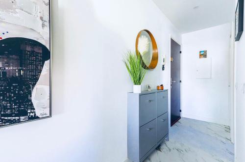 un couloir avec une commode et un miroir mural dans l'établissement Studio Azur face à la mer - French Riviera, à Villeneuve-Loubet