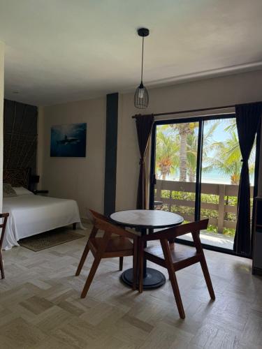a room with a table and a bed and a window at Hotel Villas Tiburon Adults Only in Holbox Island