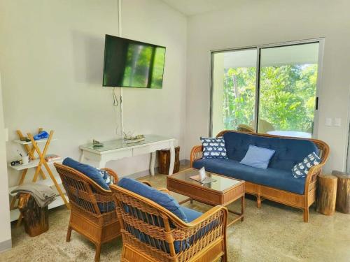 a living room with a blue couch and chairs at Casa Ballena with Beach Access and Private Pool in Uvita