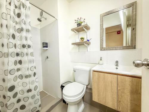 a bathroom with a toilet and a sink and a mirror at Nuevo exclusivo con vista al mar - Blue One in Lima