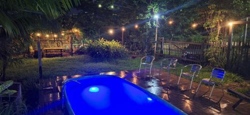 a backyard at night with chairs and a hot tub at Espaço Sairé - 8 minutos da Praia in Alter do Chao