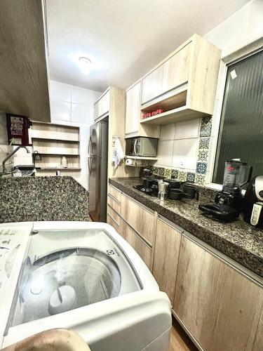 a kitchen with a sink in the middle of it at Apart Zen Santa Inês in Imperatriz