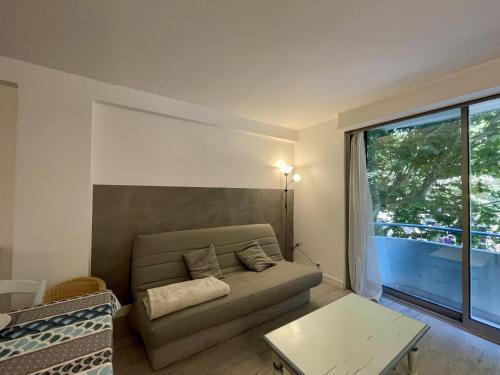 un salon avec un canapé et une grande fenêtre dans l'établissement T2 confortable à Sète avec climatisation et WIFI - FR-1-338-598, à Sète