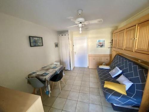 un salon avec un canapé bleu et une table dans l'établissement Studio cabine climatisé, terrasse et parking proche plage - FR-1-338-604, à Sète