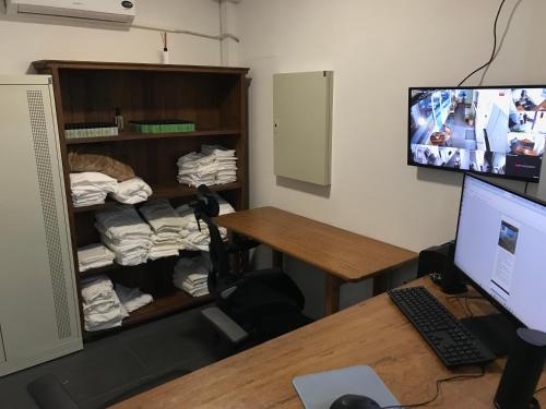 a room with a desk with a computer monitor and a room with a closet at Ô de casa hostel in Balneário Camboriú