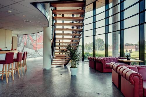 a lobby with couches and a staircase in a building at Amedia Amsterdam Airport Schiphol, Trademark Collection by Wyndham in Schiphol