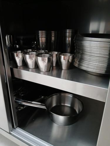 a row of stainless steel pots and pans in an oven at Ô de casa hostel in Balneário Camboriú
