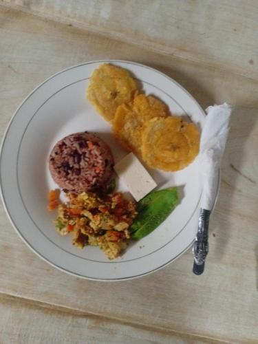 a white plate with food on a table at Eco lodge finca magdalena in Altagracia