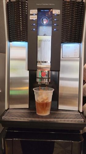 a coffee machine with a cup of coffee in it at JB Design Hotel in Busan