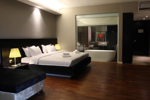 a bedroom with a large bed and a bath tub at The Shore Hotel & Residences in Melaka