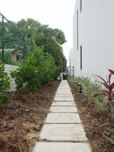a sidewalk in front of a white building at The Carlton Barbados - Luxury Townhouse Rental in Saint James