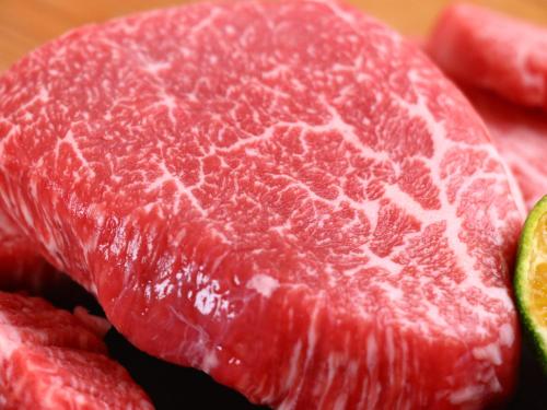 a close up of a piece of meat and some watermelon at 宿屋lotus in Ishigaki Island