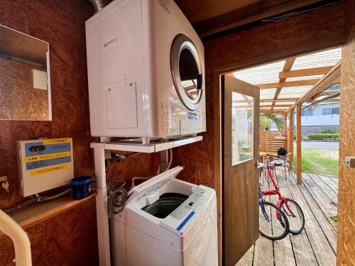 a washer and dryer in a room with a bike at 宿屋lotus in Ishigaki Island