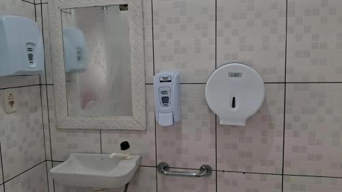 a bathroom with a sink and a mirror at Pousada Vida & Brisa in Pelotas