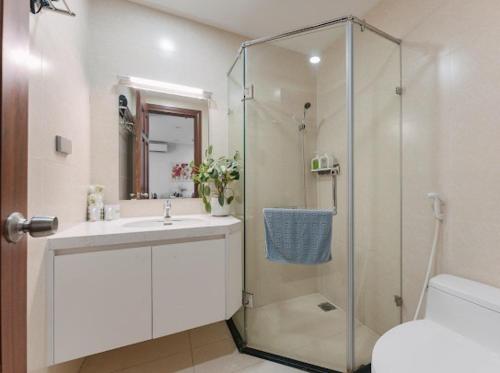 Un baño con ducha, lavabo e inodoro. en Great Quality 2Bedroom Apt In Vinhomes Green Bay, en Hanói